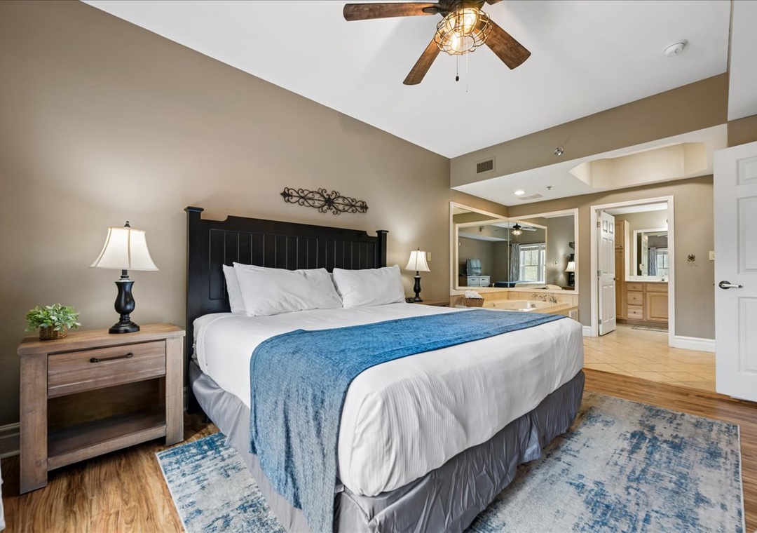 Relax in your spacious bedroom featuring a comfortable king bed, warm wood accents, and peaceful blue touches throughout.