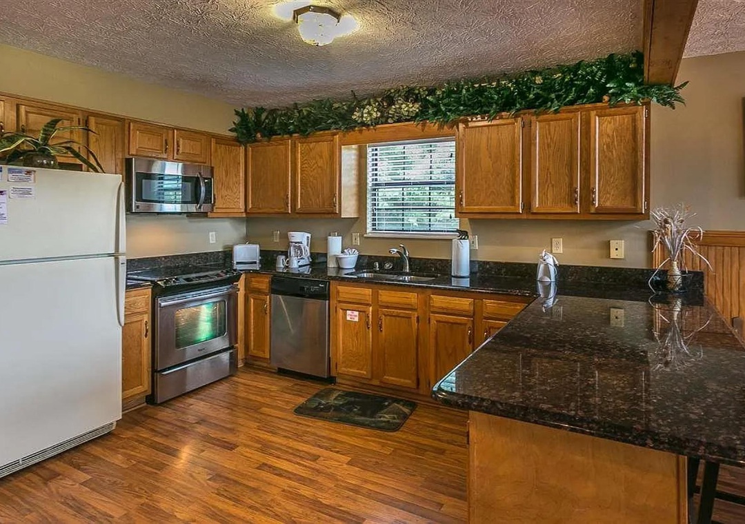 Your fully-equipped kitchen features warm oak cabinetry, gleaming granite counters, and modern appliances—ready for preparing meals and gathering with loved ones.