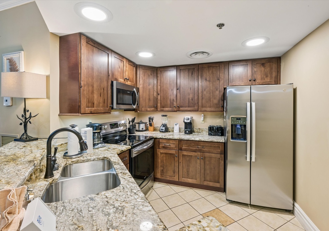Your fully equipped kitchen features granite countertops, stainless steel appliances, and warm wood cabinets—perfect for preparing meals during your stay.
