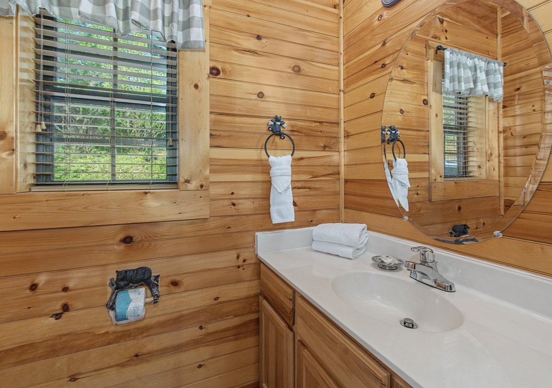 Refresh in your rustic log cabin bathroom with warm wood walls, fluffy towels, and natural light streaming through the windows.