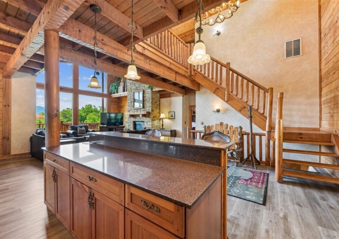 Gather around the spacious kitchen island in this stunning open-concept cabin, where exposed beams, soaring ceilings, and natural light create a warm mountain retreat perfect for your getaway.