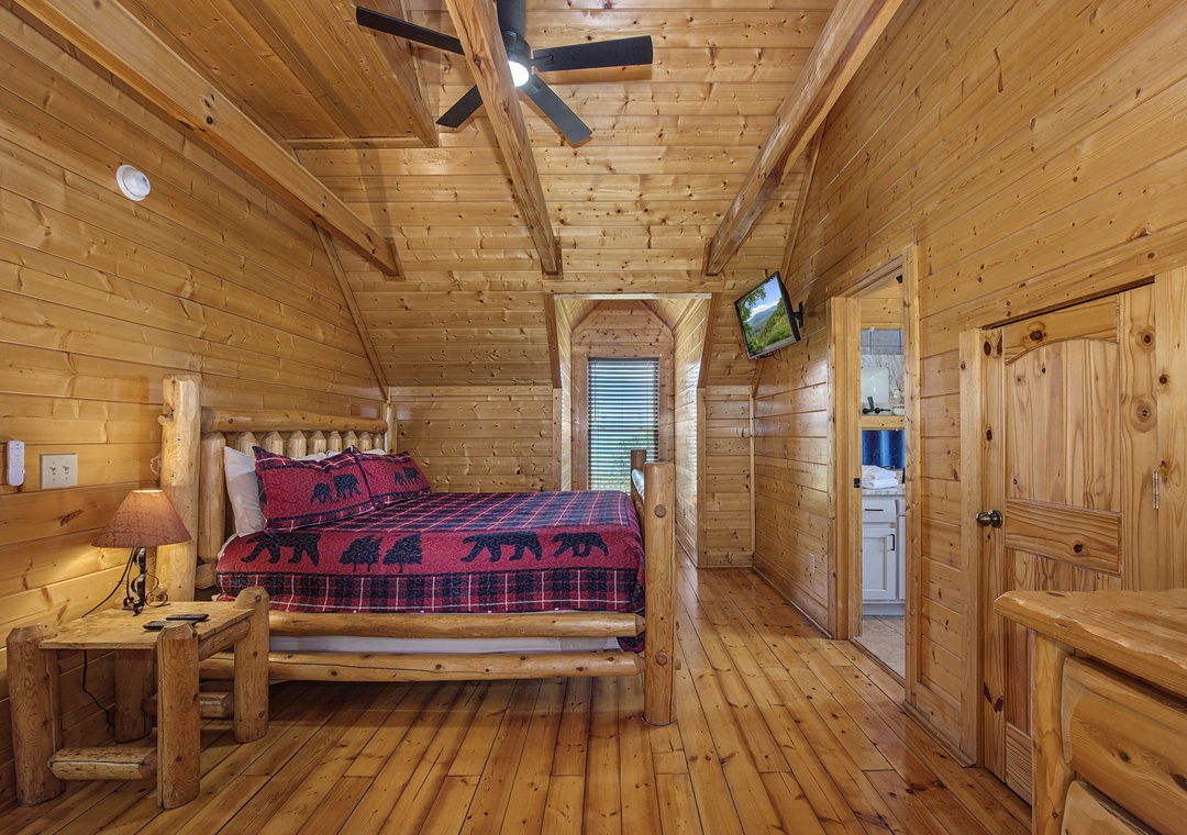 Rest peacefully in your rustic log cabin bedroom, where warm wood surrounds you and cozy bear-print bedding awaits your mountain retreat.