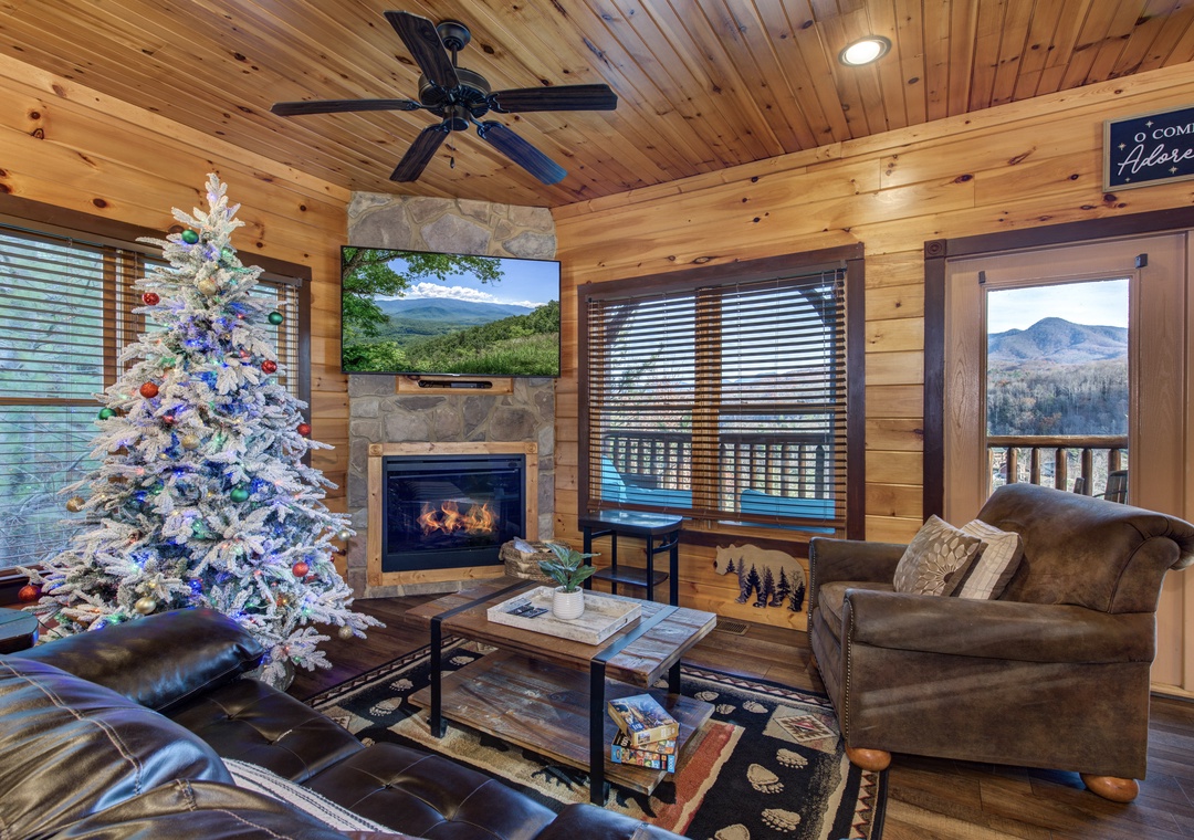 Relax in your cozy living space with mountain views through the windows, a warm fireplace, and comfortable seating perfect for unwinding after exploring the area.