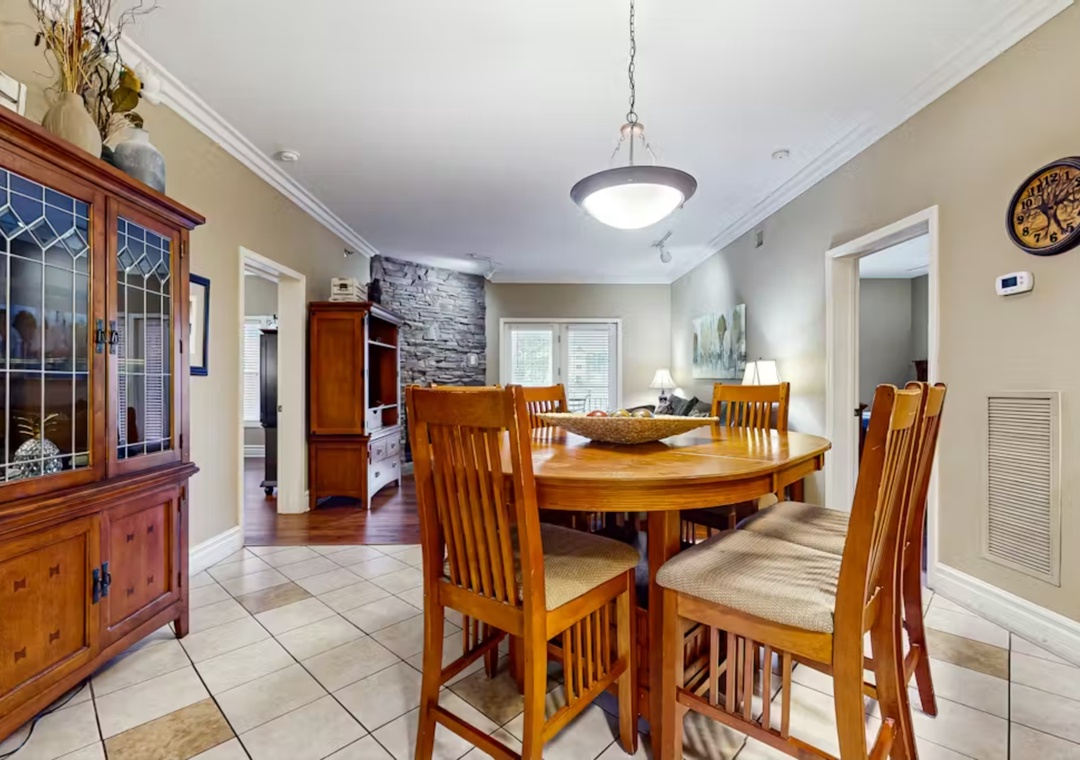 Gather around this beautiful wooden dining table where your family meals become cherished memories in this warm, inviting space.