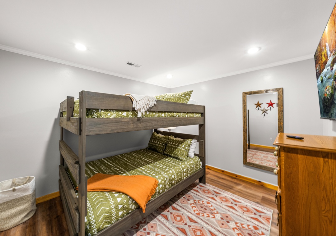 Cozy bunk room perfect for kids or friends, with cheerful bedding, warm wood tones, and plenty of space for your group to rest after adventure-filled days.