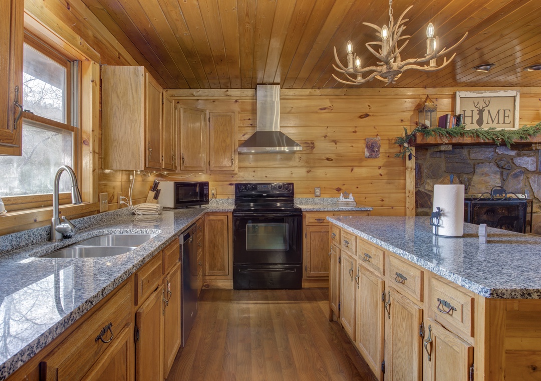 Your mountain kitchen welcomes you with warm wood cabinets, granite countertops, and rustic charm enhanced by an antler chandelier.