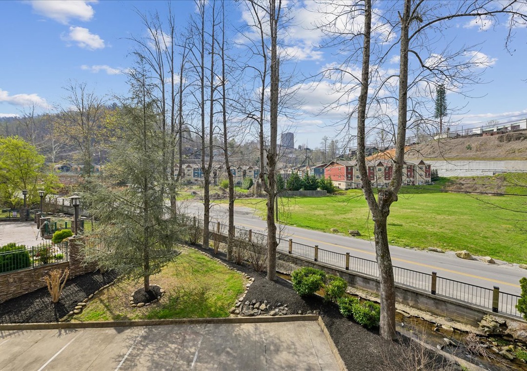 Peaceful neighborhood view with lush green spaces, charming residential buildings, and tree-lined streets creating a serene suburban setting.