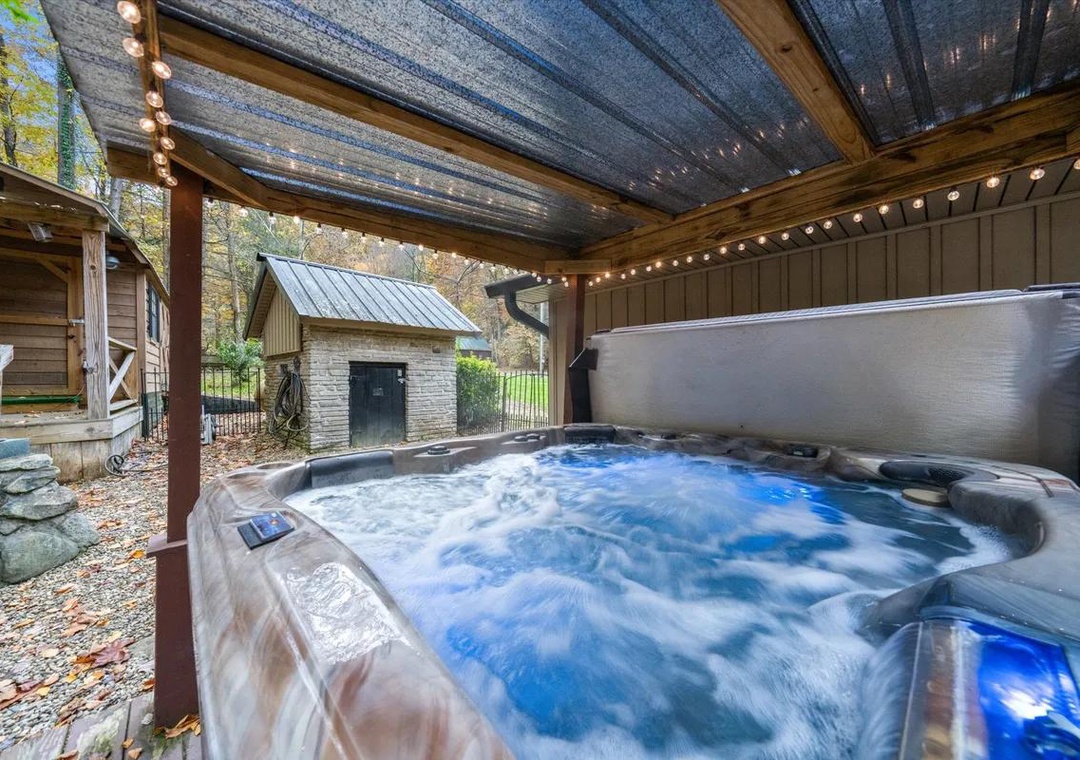 Slip into the bubbling hot tub under the covered patio, where string lights and autumn leaves set the perfect scene for your evening unwind.