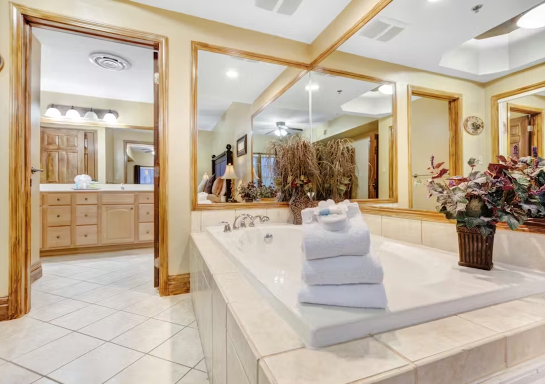 Unwind in your luxurious en-suite bathroom, featuring marble countertops, gold-framed mirrors, and plush towels ready for your arrival.