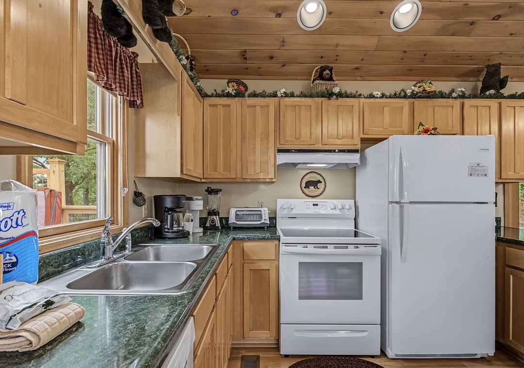 Your cozy cabin kitchen offers everything you need—gleaming appliances, warm wood cabinetry, and charming rustic touches that make meal prep feel like a mountain retreat.