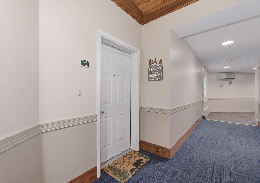 Clean, welcoming hallway with charming mountain-themed decor leads to your private retreat.