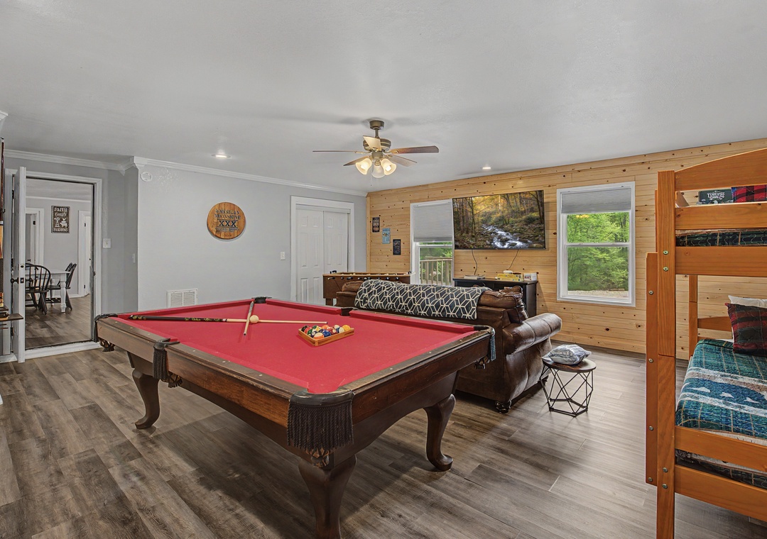 Your perfect game room awaits with a stunning red-felt pool table, cozy leather seating, and rustic wood accents for memorable evenings.