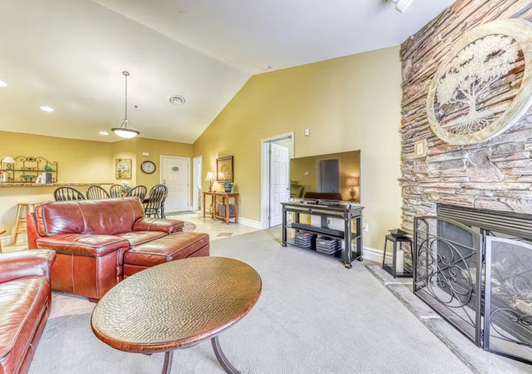 Unwind in your spacious living area with plush leather seating, crackling fireplace, and entertainment center for cozy evenings together.