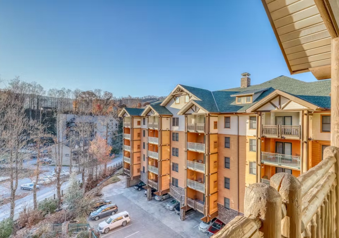 Mountain resort buildings nestled among winter trees with convenient parking and scenic surroundings.