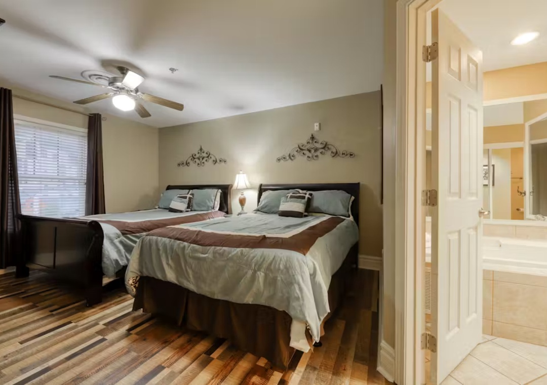 Rest peacefully in your elegantly appointed bedroom featuring two comfortable beds, decorative wall art, and an ensuite bathroom for your convenience.