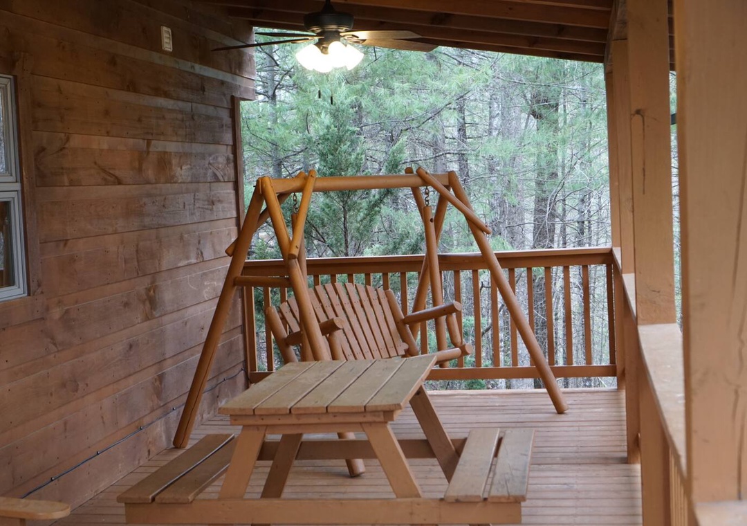 Gentle forest breezes sway your private porch swing while you sip morning coffee, surrounded by towering trees.