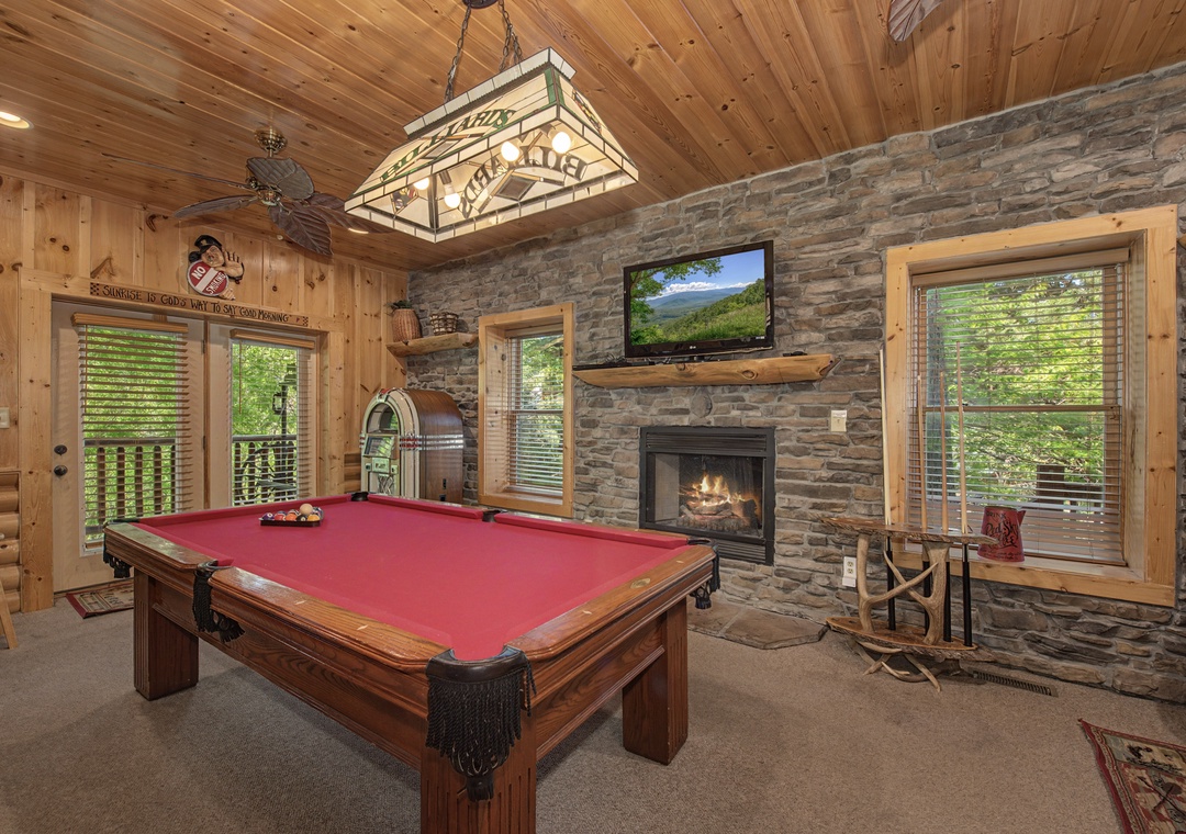 Gather around the pool table for friendly competition while the fireplace crackles nearby, creating your perfect cabin game night.