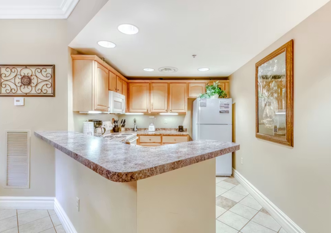 Step into your fully equipped kitchen featuring granite countertops, warm wood cabinets, and everything needed for memorable meals during your stay.
