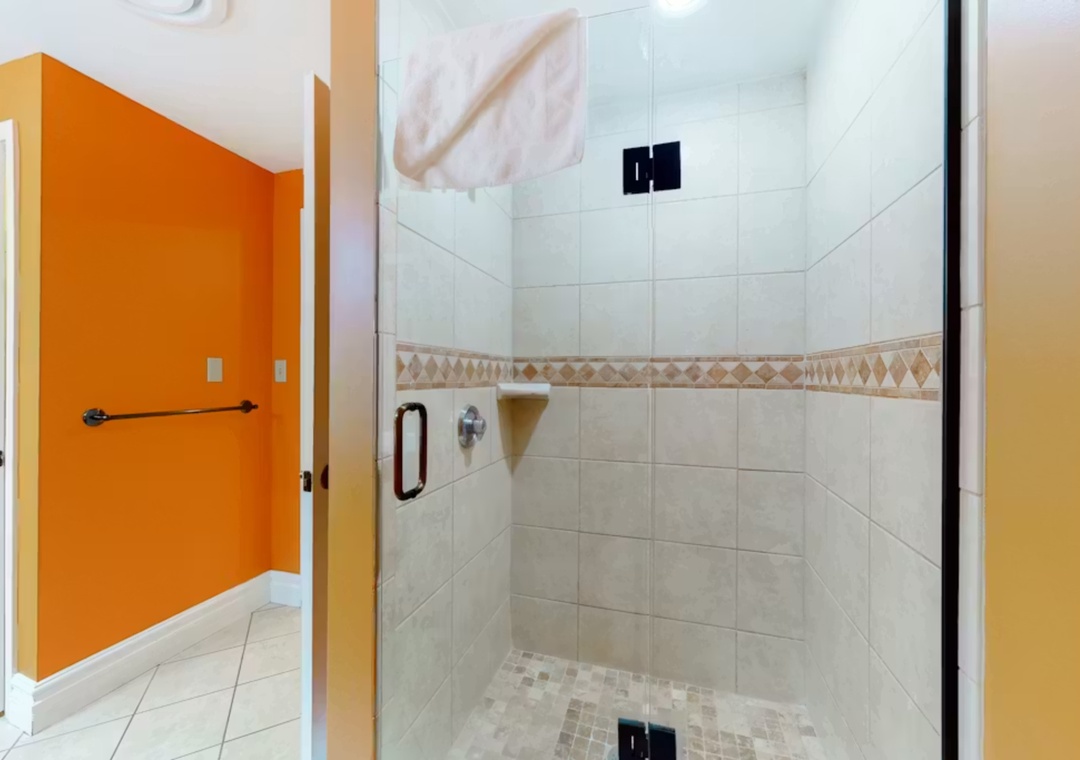 Your private spa-like shower awaits with elegant tiling and a spacious glass enclosure for a refreshing start to each day.