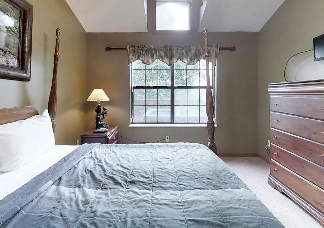 Sink into plush bedding beneath a skylight that floods your room with natural light. Classic furnishings and warm tones create a cozy retreat after a day of mountain adventures.