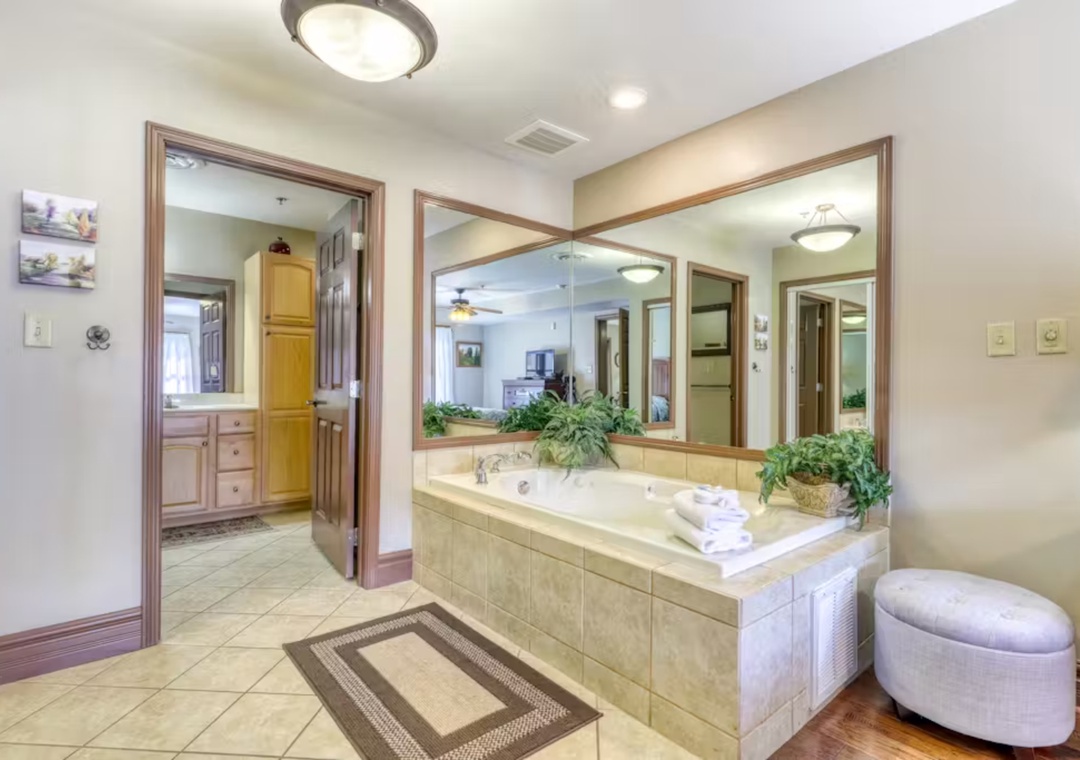 Unwind in your luxurious master bathroom with a spacious soaking tub, fresh towels, and elegant mirrors reflecting pure relaxation.