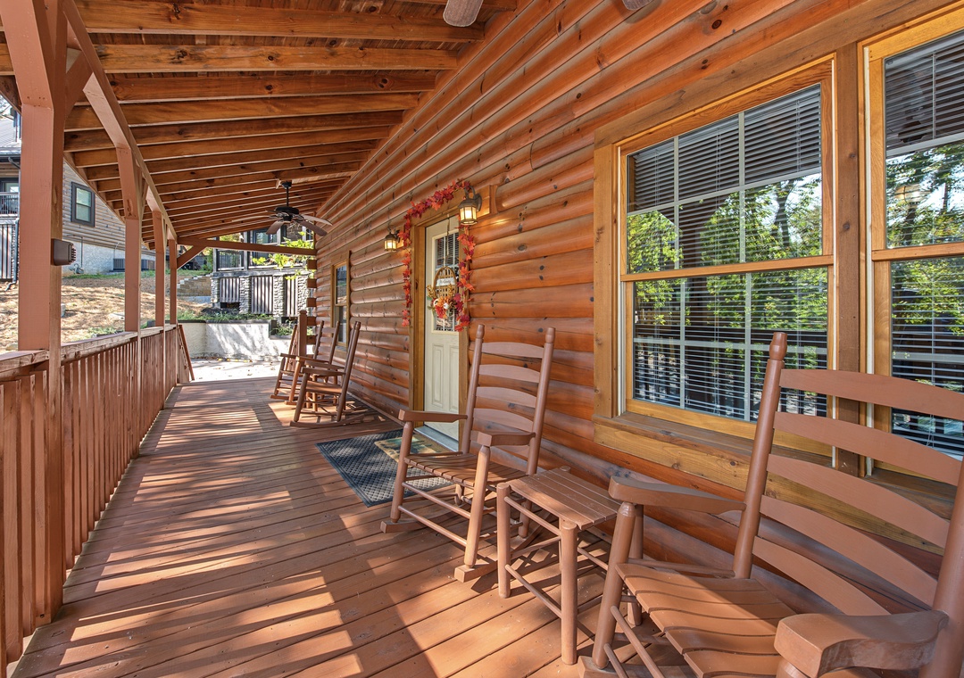 A covered porch providing a peaceful retreat surrounded by nature, with classic wooden chairs and plenty of shade for outdoor relaxation.