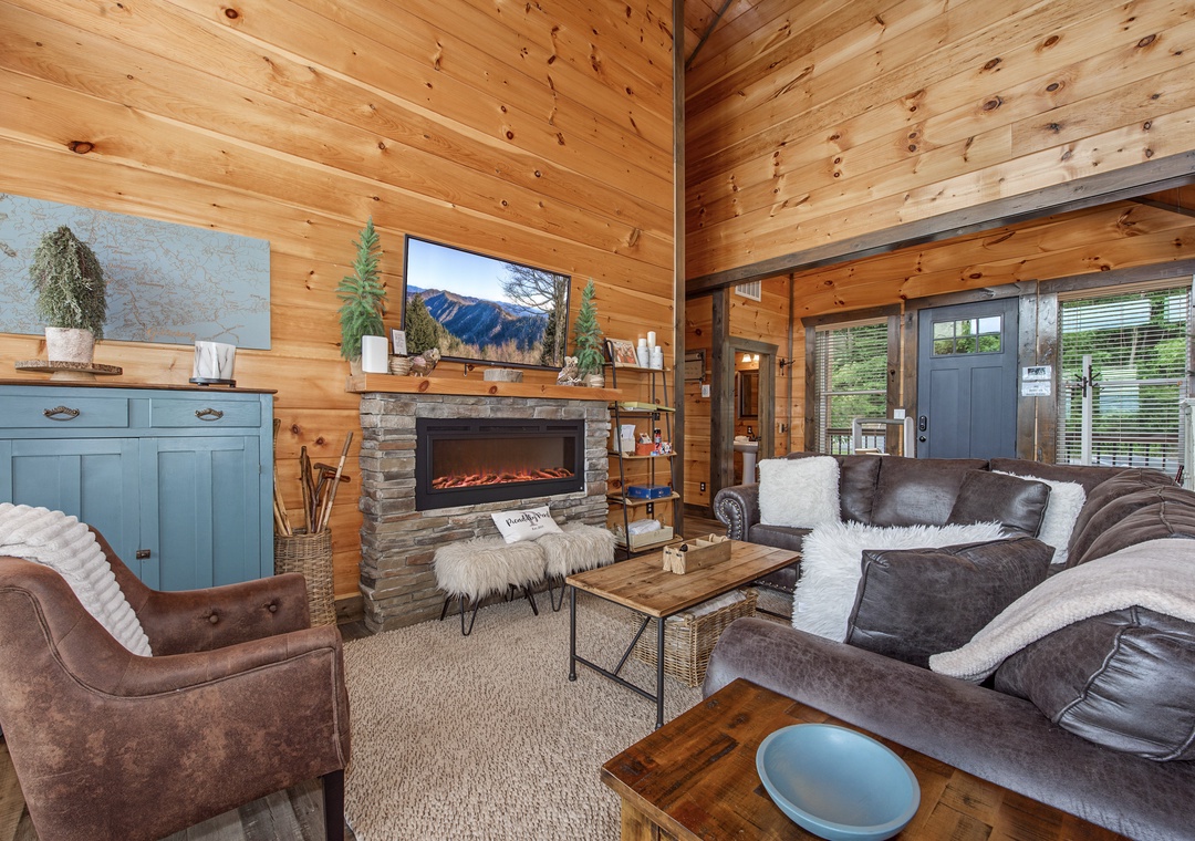 Sink into plush seating and warm up by the fireplace in this welcoming living room, where natural wood surrounds you and mountain views catch your eye.