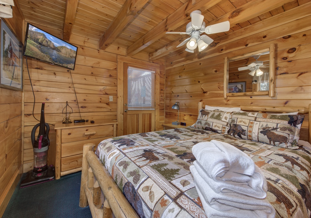 Cozy log cabin bedroom where rustic charm meets comfort. Fresh towels await your arrival in this woodsy retreat.