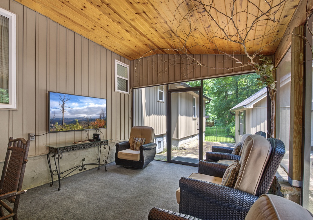 Relax in your private screened porch with comfortable seating and vaulted wood ceilings. The space opens to a peaceful backyard, perfect for your morning coffee or unwinding after a day of exploring.