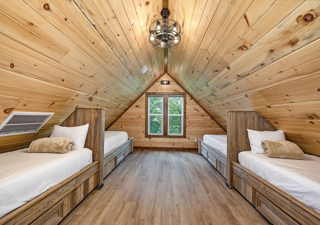 Retreat to your cozy loft bedroom under soaring timber ceilings, where crisp linens and rustic wood charm invite restful nights in a warm, cabin-style escape.