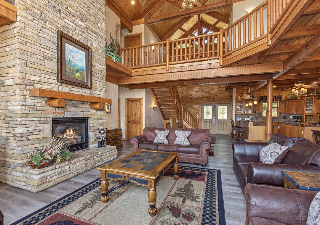 Step into your mountain retreat where soaring timber beams and a grand stone fireplace set the stage for cozy evenings. Sink into plush leather seating in this open, airy living space that blends rustic charm with all the comfort you need.