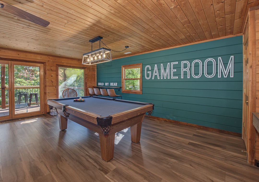 Step into your own game room with a full-size pool table, soaring wood-planked ceilings, and natural light pouring through the windows—your perfect spot for friendly competition and making memories.
