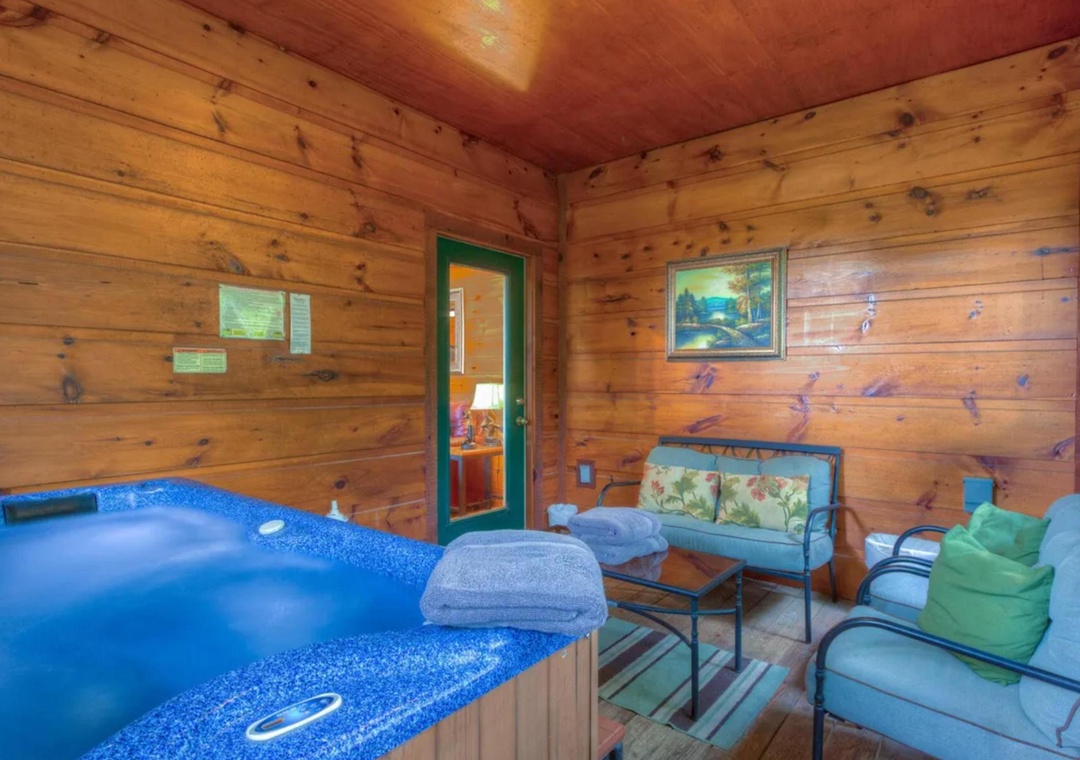 Unwind in your private hot tub surrounded by warm knotty pine walls, with comfy seating perfect for reading or simply soaking up the cozy, cabin-like atmosphere.
