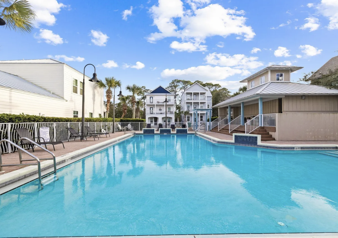 Community pool area showcasing surrounding architecture, tropical landscaping, and resort-style amenities within the property grounds.