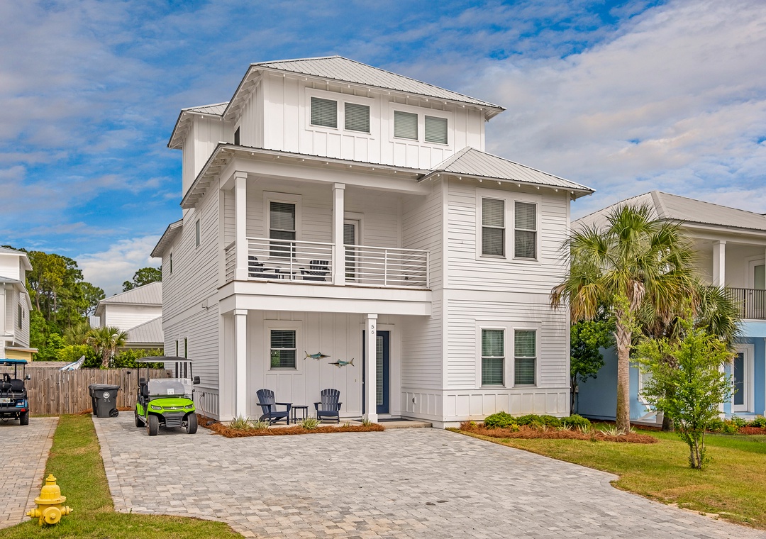 A bright coastal-style home featuring modern architecture with balconies, palm trees, and convenient parking right at your arrival.