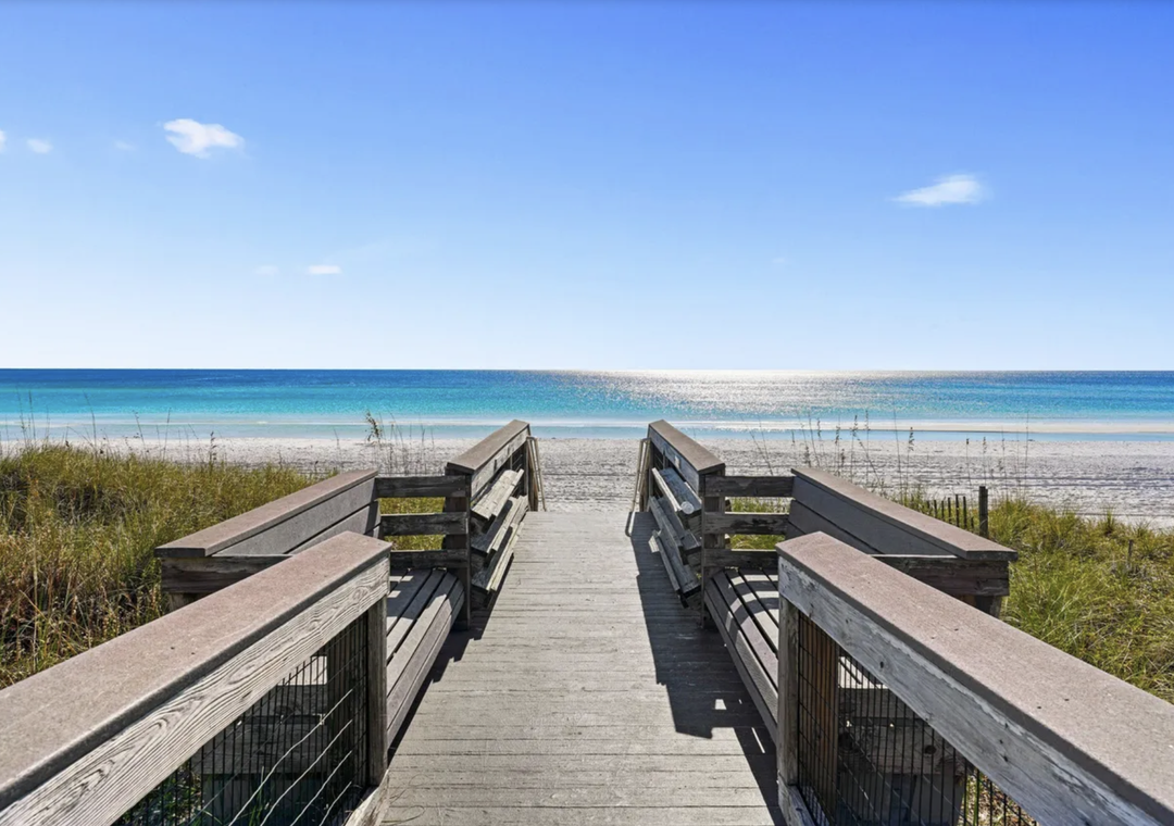 A welcoming boardwalk pathway leads directly to pristine white sand beach and crystal-clear turquoise waters, perfect for your seaside escape.
