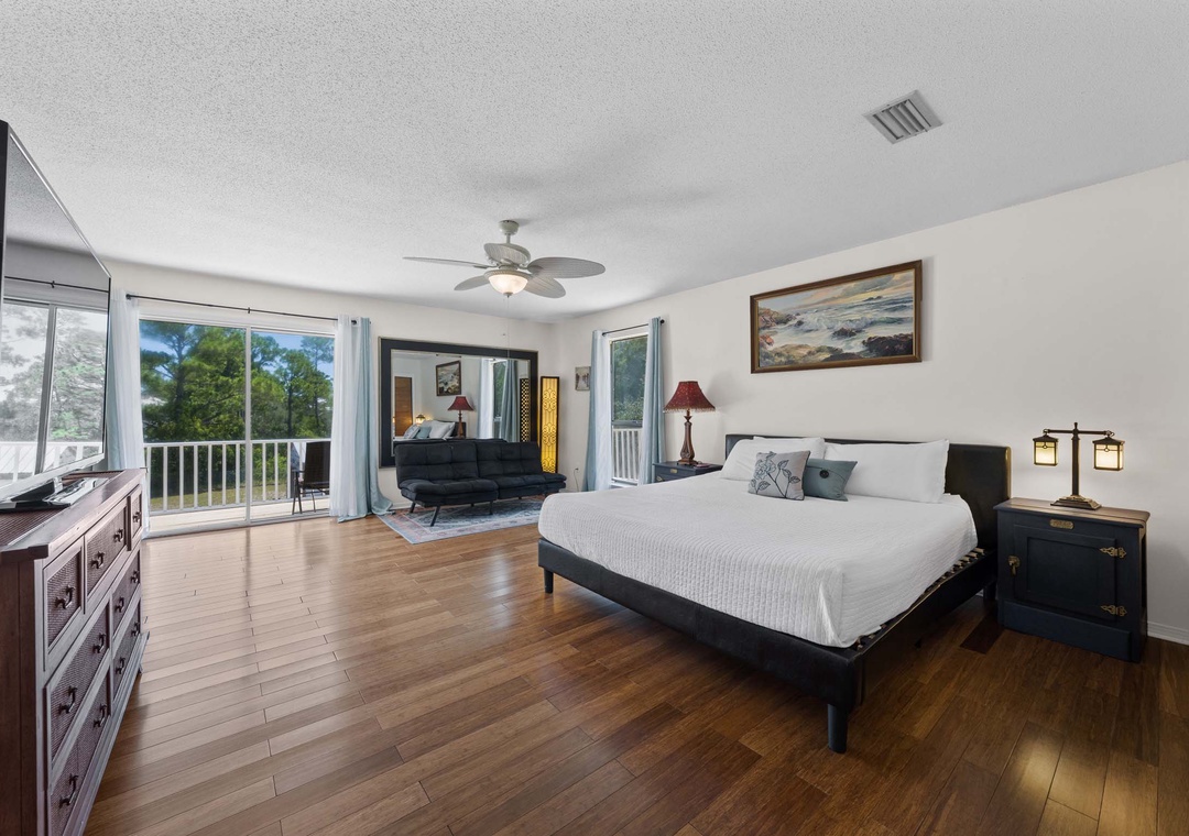 Second floor primary suite with balcony access, king bed, and futon