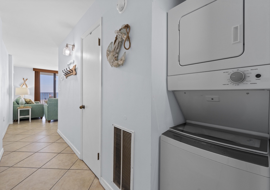 Hallway with stacked washer and dryer
