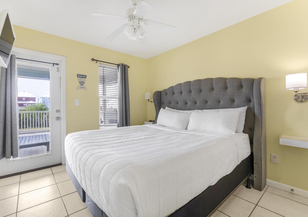 Primary bedroom with king bed and balcony access