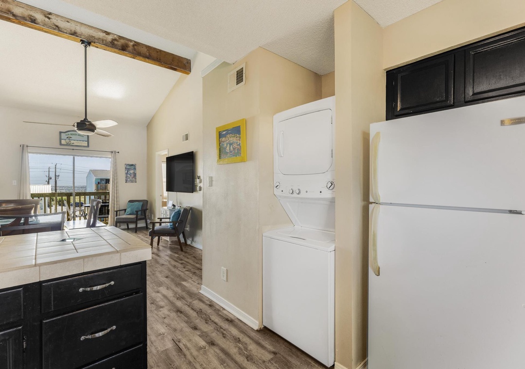 In-unit stacked washer and dryer next to the refrigerator