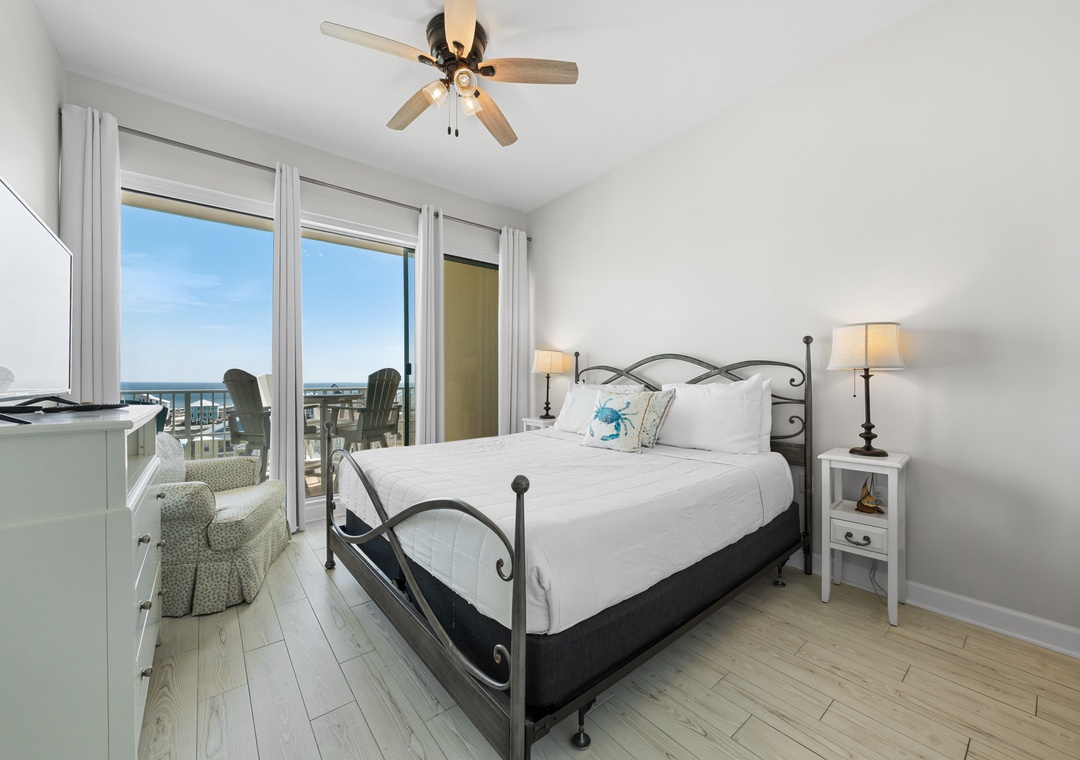 Primary bedroom with king bed and balcony access