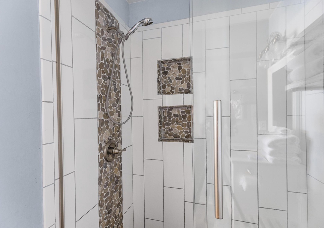 Walk-in shower with pebble tile accents