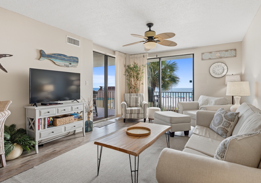 Living room with balcony access and a large flat-screen TV