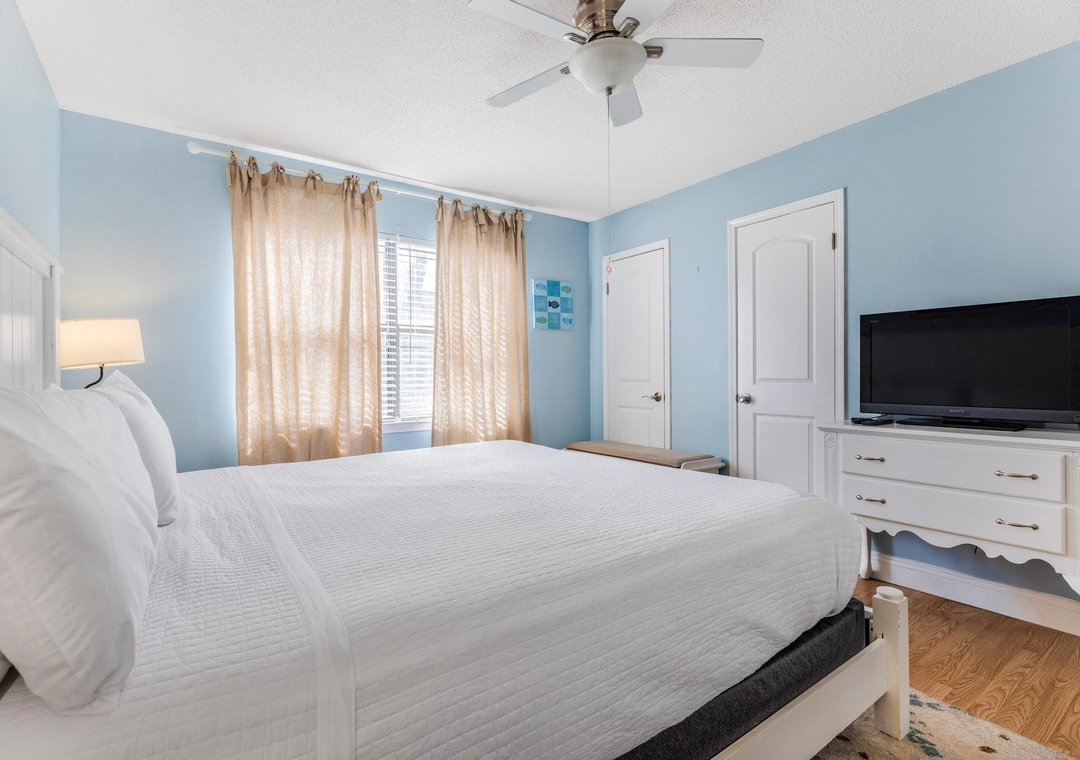 Primary bedroom with king bed and dresser