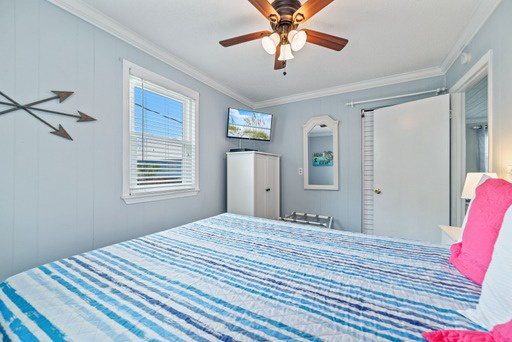 Primary bedroom with queen bed and mounted TV