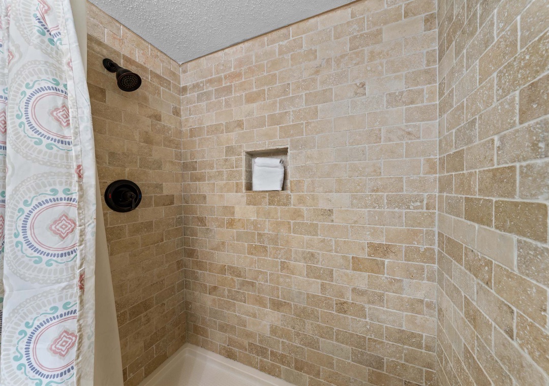 Tiled shower/tub combo in the full bathroom