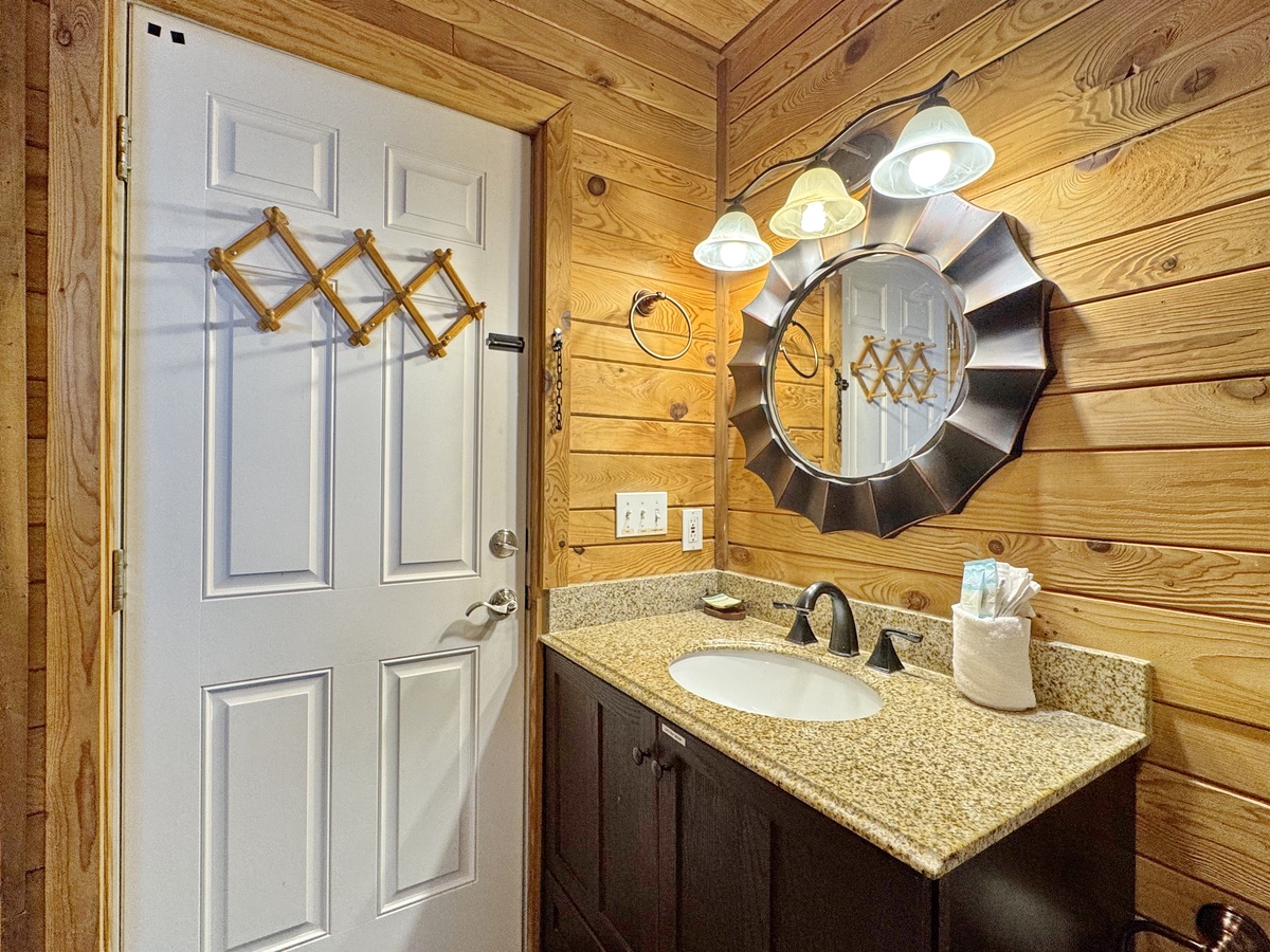 Warm rustic charm awaits in your private bathroom with natural wood walls and granite countertops for mountain cabin comfort.