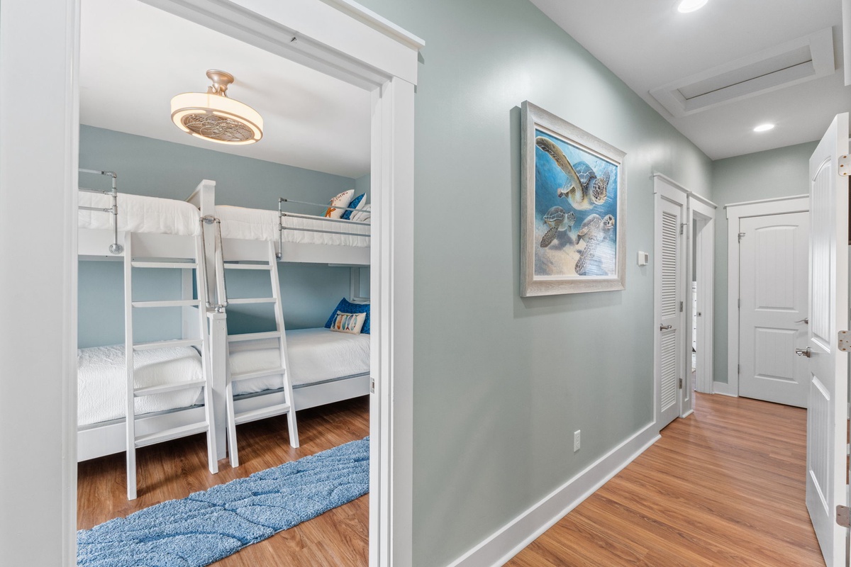 Step into this charming coastal-themed bedroom with cheerful bunk beds perfect for kids. Soft blue accents and playful sea turtle art create a welcoming space where your family can unwind after beach adventures.