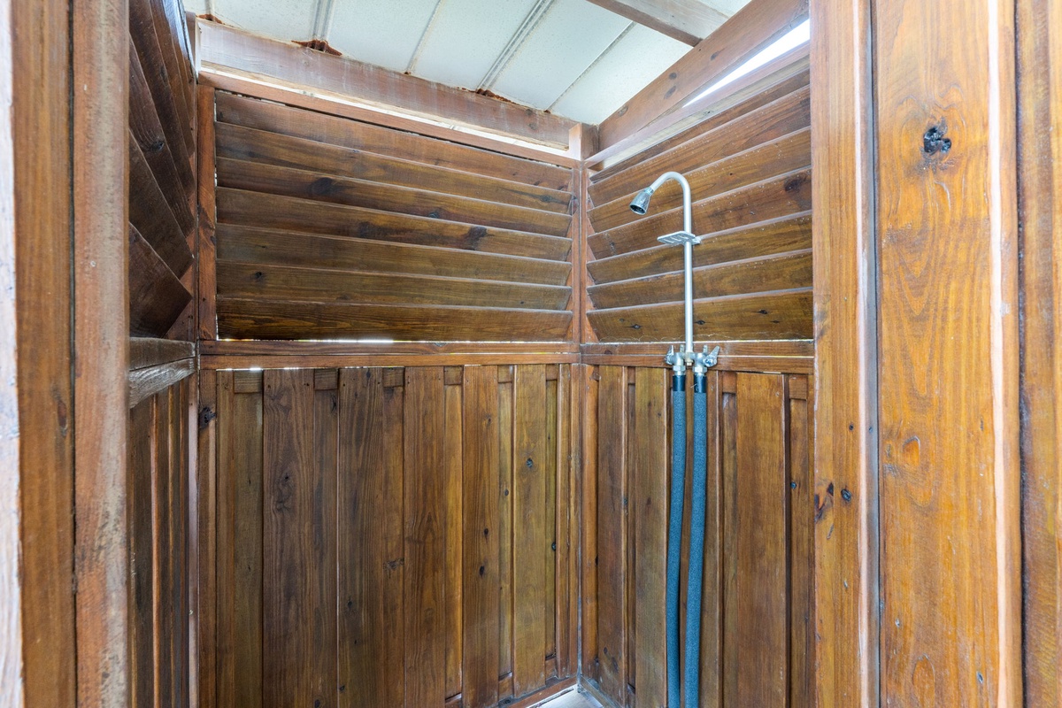 Rustic wooden outdoor shower with natural light—rinse off after beach adventures or refresh between activities in complete privacy.