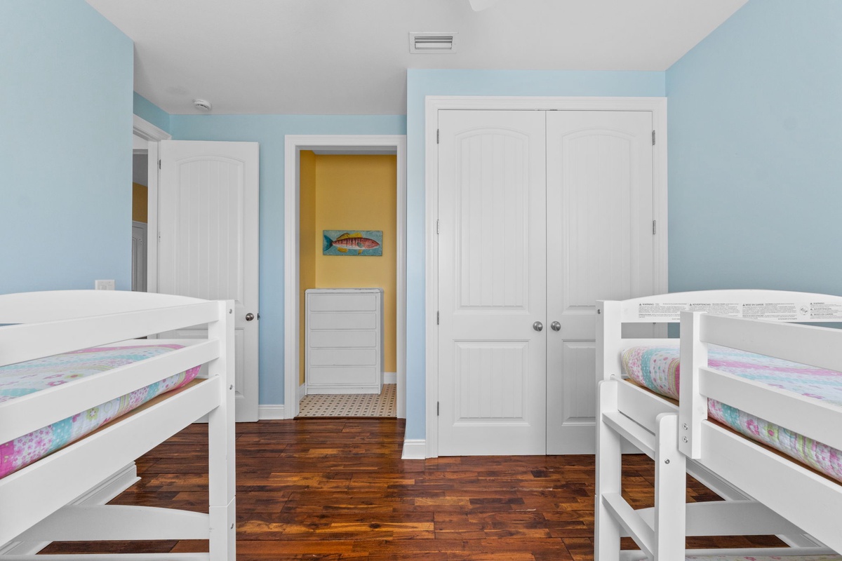 Your coastal retreat features two comfortable bunk beds, perfect for kids or groups. Soft blue walls and warm wood floors create a cheerful, beach-inspired space where everyone can rest after a day of adventure.